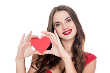 smiling girl in red dress showing paper heart isolated on white, valentines day concept