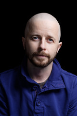 Obraz premium Bald bearded caucasian man in his 30s isolated on black background. 24mp file shot in a studio setting.