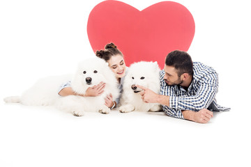 Obraz na płótnie Canvas couple lying with dogs on white, valentines day concept