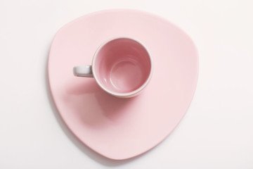 pink cup on plate on white background