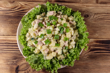 Traditional Russian festive salad Olivier on wooden table