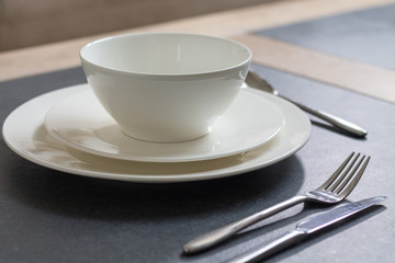 Table setting dinner plate with cutlery on dark background