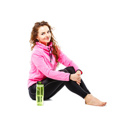 Young smiling fitness woman sitting with water bottle isolated on white background