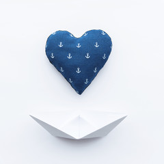 paper boats on a white matte background and heart with an anchor