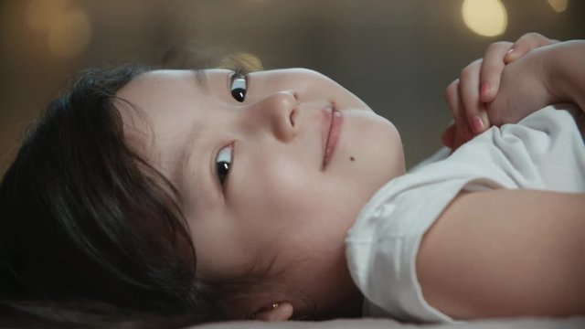 little 5-6 years old cute asian girl smiling and dreaming while sleeping