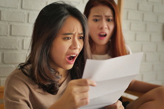 frustrated, shocked women looking at expensive bill or debt notice invoice