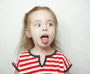 Adorablr little girl pulls her tongue out and looks sideways