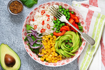 Plate with salad, corn, avocado and rice on a concrete background!