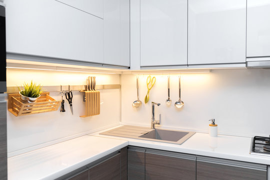 white gloss kitchen interior with worktop lighting