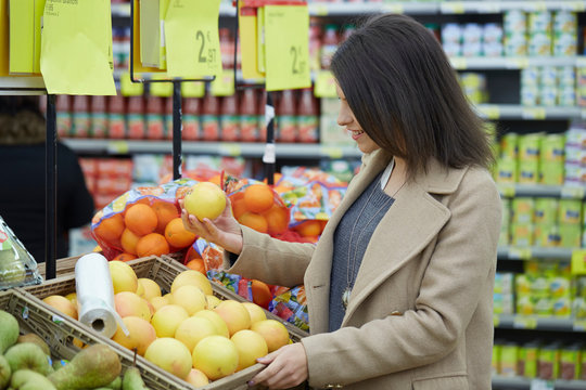 young brunette buy fruits and vegetables at supermarket