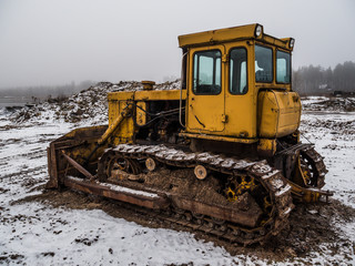 old yellow bulldozer at winter in a workplace