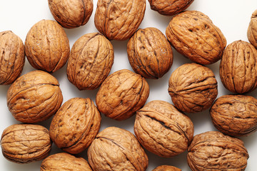 Closed walnuts on white table