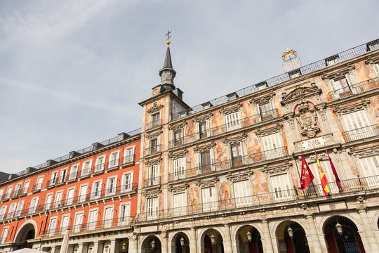 Detail of a decorated facade with traditional windows and balconies at the Palza Mayor, Madrid, Spain.