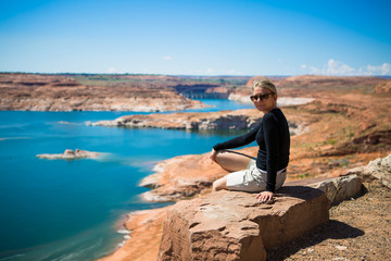 Fototapeta na wymiar Beautiful young tourist woman watching lake Powell amazing panorama. Famous touristic places in USA. American city travel concept.