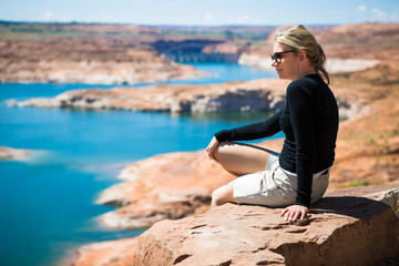 Fototapeta na wymiar Beautiful young tourist woman watching lake Powell amazing panorama. Famous touristic places in USA. American city travel concept.