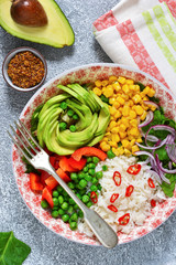 Plate with salad, corn, avocado and rice on a concrete background!