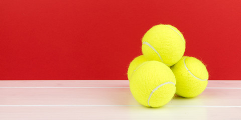 four tennis balls with red background panorama