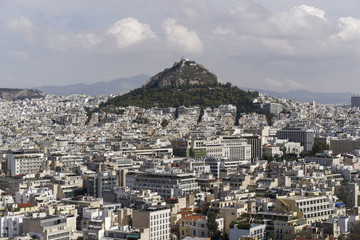 Naklejka premium Athens, Greece Mount Lycabettus day view. Panoramic view of Lykavittos hill and surrounding cityscape buildings from Athens Acropolis.