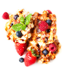 Traditional belgian waffles with fresh fruit, ice-cream  and caramel isolated on white background, top view.