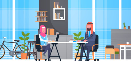 Arabic Business Man And Woman Sitting At Office Desk In Modern Coworking Space Working Together Muslim Workers In Coworkers Center Flat Vector Illustration