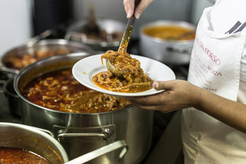 The cook puts tripe in the plate