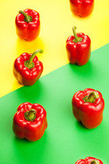 Fresh healthy sweet red peppers over two colored background in yellow and green