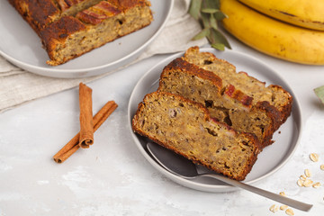 Sliced vegan banana bread with cinnamon in gray plates. Gray background. Vegan Healthy Food Concept. Top view