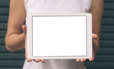 Close-up of female hands showing and using modern digital tablet with blank screen for your text message, mock-up of template tablet pc, hipster girl sitting at the park with technology outside.