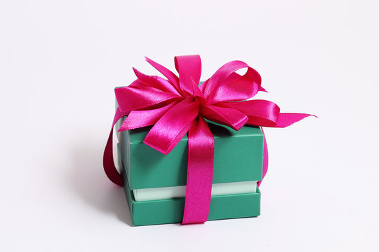 Green square gift box with a pink bow on a white background