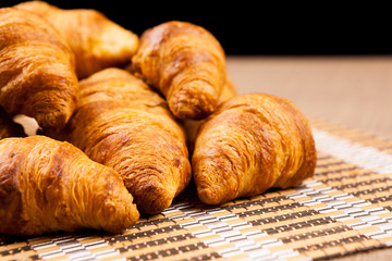 Close up on fresh baked golden croissants lying on a tables