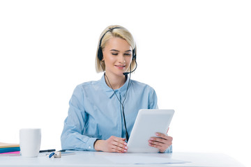 portrait of young call center operator in headset using tablet at workplace isolated on white