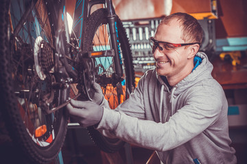 Fototapeta na wymiar bike mechanic repairs bicycle in workshop
