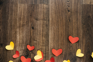 Fototapeta premium Valentine 's Day background, red and yellow hearts on wood texture
