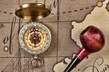 tobacco pipe and compass on map