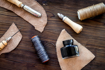 Leather craft accessories. Tools and matherials on dark wooden b