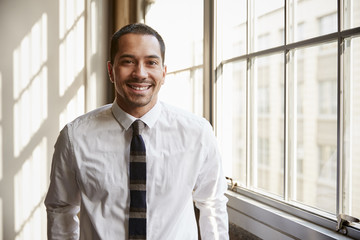 Fototapeta premium Young Hispanic businessman smiling to camera, close up