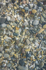 sea pebble beach with multicoloured stones, waves with foam