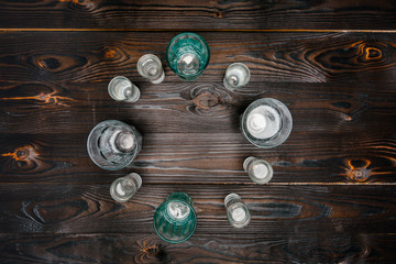top view of circle with different sized glasses with water on wooden table