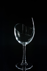 broken wineglass on black reflecting table