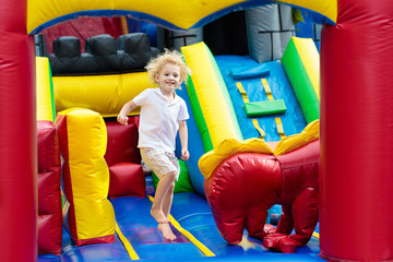 Fototapeta na wymiar Child jumping on playground trampoline. Kids jump.