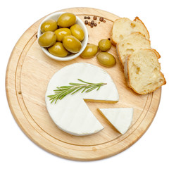 Round brie or camambert cheese on cutting board white background