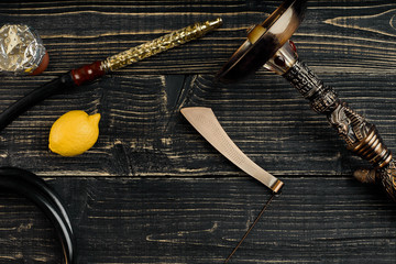 Dismantled parts of hookah on a wooden background with lemon fru