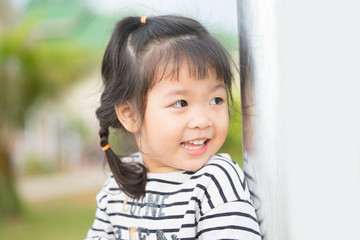 Little girl child showing front teeth with big smile: Healthy happy funny smiling face young adorable lovely female kid with new tooth dental loss: Joyful portrait of asian elementary school student