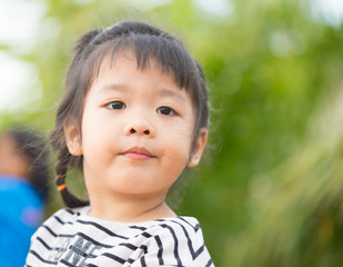 Little girl child showing front teeth with big smile: Healthy happy funny smiling face young adorable lovely female kid with new tooth dental loss: Joyful portrait of asian elementary school student