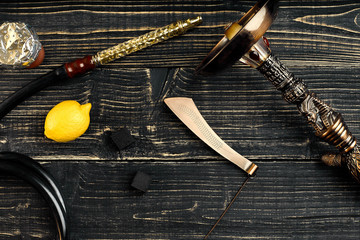 Dismantled parts of hookah on a wooden background with lemon fru