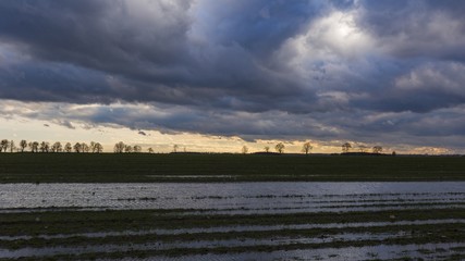 Flooded field under dark cloudy skies