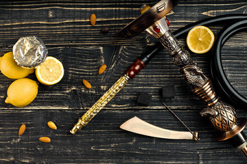 Dismantled parts of hookah on a wooden background with lemon fru