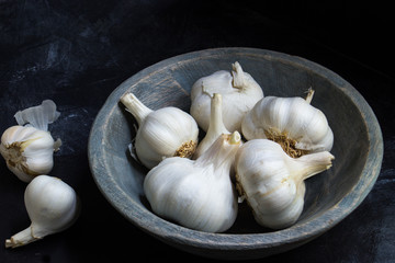Knoblauchknollen in Holzschale als Stimmungsbild