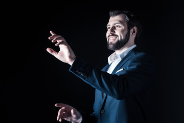 Technology in business. Delighted positive smart businessman smiling and looking up while using modern technology