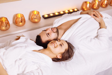 man and woman lying down on massage beds at Asian luxury spa and wellness center